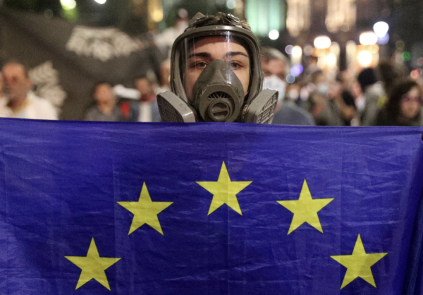 Protestor in Tbilisi, Georgia wearing a gas mask and waving an EU flag.