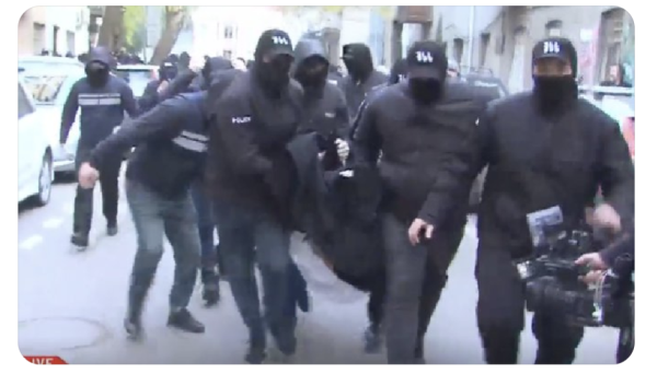 Masked police carrying the unconscious body of opposition politician in Tbilisi, Georgia 