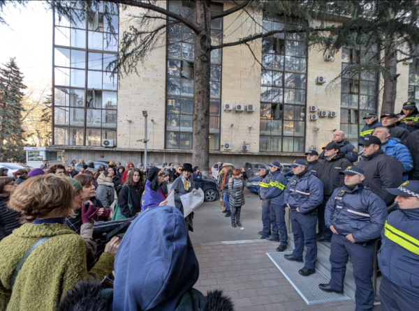 A group of women confront a group of policemen outside a police station in Georgia