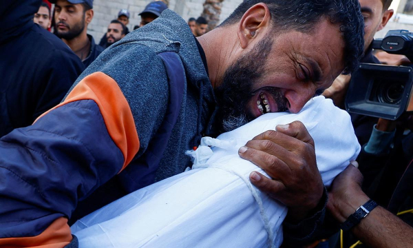 Un padre llora, abrazado al cuerpo de su hijo, asesinado por Israel, en el Hospital Nasser de Khan Younis, el 23 de noviembre de 2024. (Mohammed Salem / REUTERS)