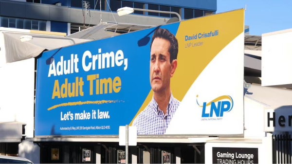 Advertising Billboard text:

Adult Crime Adult Time. Let’s Make it Law.

(Four word Law & Order election slogans of LNP politicians punching down on poorest “criminal class” aboriginal First Nations youth )
Image: current Queensland Premier “Leader” David Crisafulli (promising to jail children aged 10)