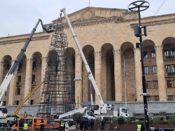 A crane erects a huge steel frame for a Christmas tree outside parliament in Tbilisi, Georgia