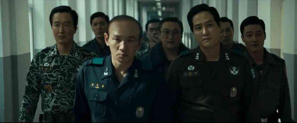 A still from the film 12.12: The Day. A group of Korean men wearing military uniforms march purposefully along a corridor.