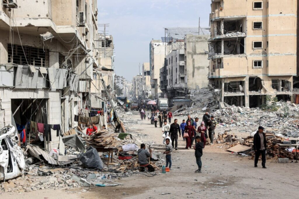 People walked past the rubble of collapsed and damaged buildings along a street in Gaza City on Wednesday amid the ongoing war in the Palestinian territory between Israel and Hamas.