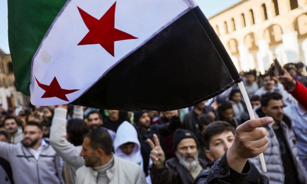 Un grupo de partidarios de la revolución enarbola banderas antes del rezo en la mezquita de Umayyad, este viernes, en Damasco. (Amr Abdallah Dalsh / REUTERS)