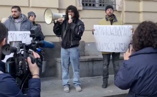 Giorgi Gigashvili addressing a crowd of protestors with a megaphone.