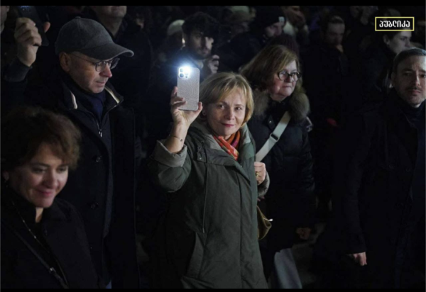 Rasa Jukneviciene holds her mobile phone aloft with the light on with protestors in Tbilisi Georgia