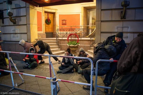 Security und Polizei versuchen Aktivist*innen der Letzten Generation an Blockade des Eingangs zum Hotel Adlon zu hindern. Aktivistinnen beginnen, sich festzukleben. Berlin, 10.12.2024