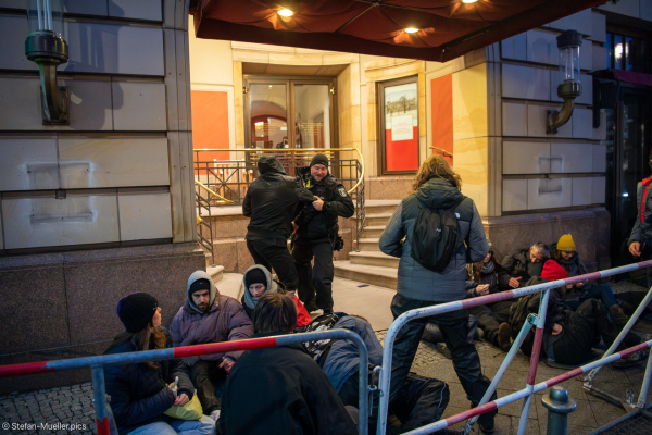 Polizist wirft Security-Mann vom Adlon mit Migrationshintergrund über Aktivist*innen der Letzten Generation. Bei  Blockade der LG am Hintereingang des Adlons während des World LNG Summits, Berlin, 10.12.2024