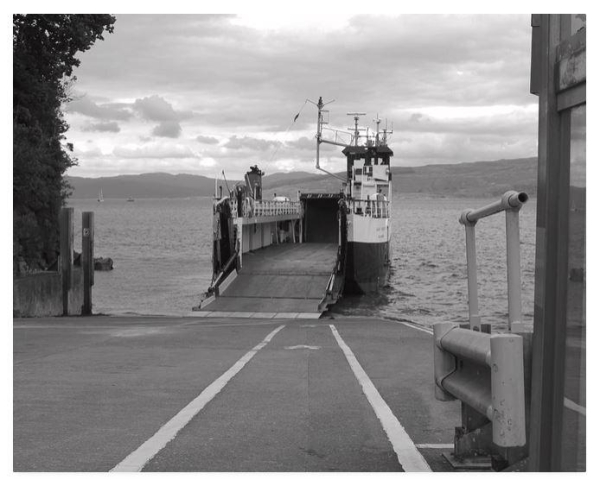 Black and white photograph showing a docked empty car ferry awaiting vehicles.