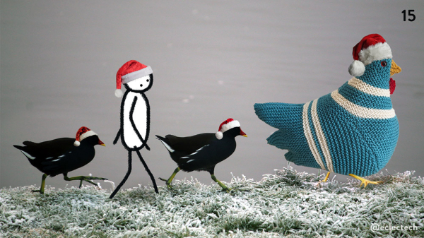 A photo of a riverbank. At the bottom a section of frost covered grass, then a background of flat grey water Along the edge of the grass walk 4 figures, all wearing Santa hats. Leading the pack is Myfanwy, a large cream and teal knitted chicken. Behind her a moorhen, behind them Friend, a simple drawn figure, then another moorhen at the back, this last one lifting one of its legs up so you can see the amazing long feet. I'm not sure where they are going.