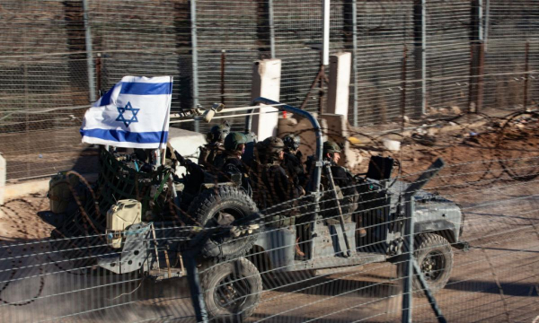 Tropas israelíes y vehículos militares entran y salen de Siria a través de una puerta en la valla fronteriza en los Altos del Golán anexados por Israel. (Mati Milstein/NurPhoto via Getty Images)