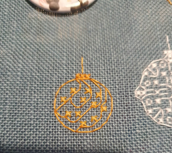 Up near the top of the pattern is a small gold bauble, again its simple lines and little crosses inside the round bauble. 