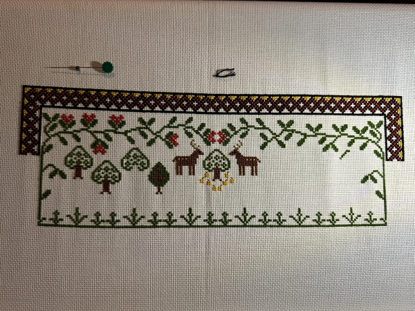 Partially completed cross stitch samplers, decorative border, foliage, stags and trees. In a folk style 