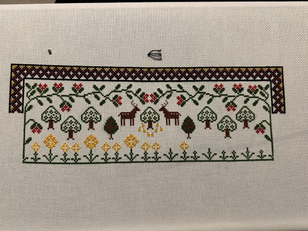 A partially completed cross stitch sample. 