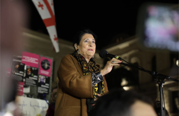 Salome Zourabichvilli at a microphone trying to address a crowd in Tbilisi Georgia.