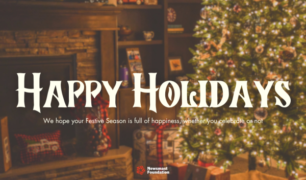 A Christmas tree can be seen covered in lights and decorations besides wrapped presents. Copy reads: Happy holidays. We hope your festive season is full of happiness, whether you celebrate or not. The Newsmast Foundation logo can be seen at the bottom.