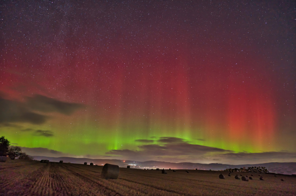 An image of the Aurora Borealis lighting up the sky with fields below. Aberdeenshire, Scotland