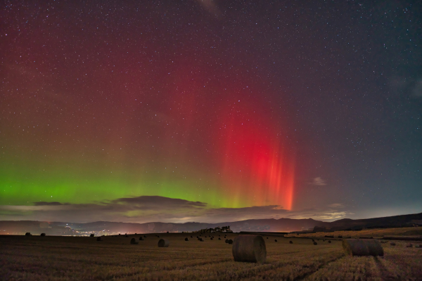 An image of the Aurora Borealis lighting up the sky with fields below. Aberdeenshire, Scotland