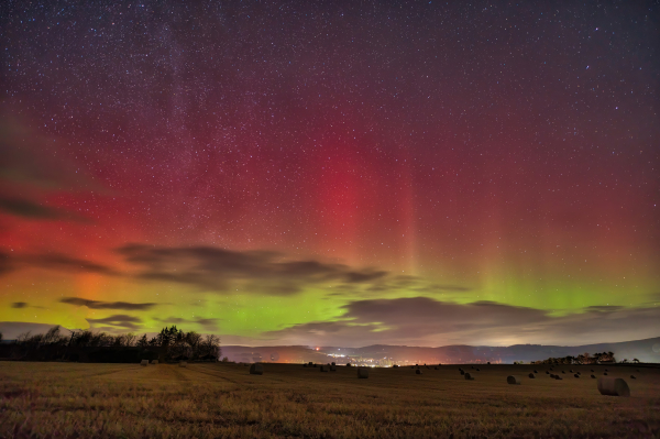 An image of the Aurora Borealis lighting up the sky with fields below. Aberdeenshire, Scotland