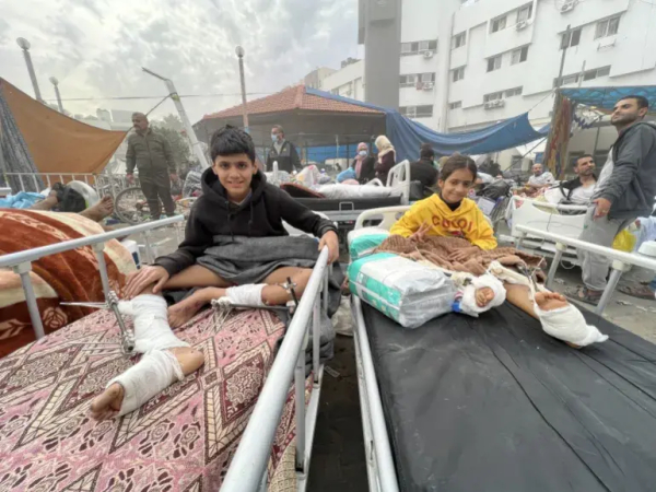 Children with wounded/amputated legs rest on hospital beds in the open in the courtyard of al-Shifa hospital.