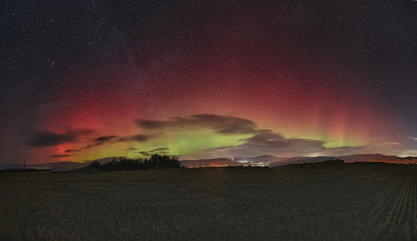 An image of a snowy landscape with an Aurora arc in the sky above. Aberdeenshire, Scotland