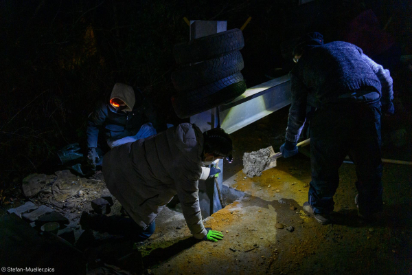 Aktivisten arbeiten an einer Straßensperre in Lützerath. Einzige Beleuchtung sind ihre Stirnlampen. Lützerath, 03.01.23