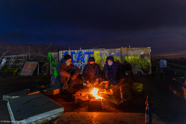 Aktivisten bewachen eine Barrikade zur Blockade einer von der Polizei angelegten Zufahrtsstraße nach Lützerath. Links steht auf einem Schild: „Achtung Tunnel“. 07.01.2023