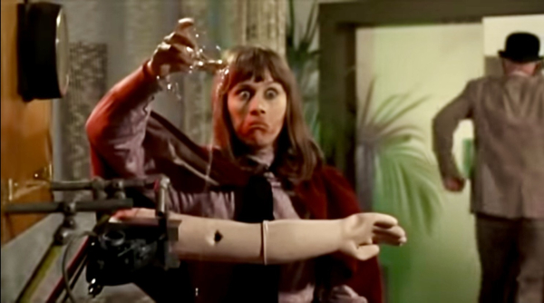 A woman with smeared lipstick pours wine on a robot arm in defiance.