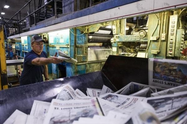 Gene Mesplay, of Crystal City, tosses a copy of the last locally printed edition of the St. Louis Post-Dispatch into a recycling bin after checking the print quality on Sunday, Jan. 5, 2025, at the Pulitzer Publishing Center in Maryland Heights.  Photo by Zachary Linhares, Post-Dispatch