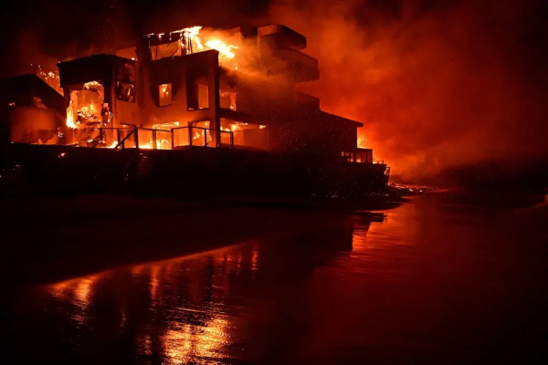 A beach house is engulfed in flames as the Palisades Fire burns along Pacific Coast Highway in Malibu, California, on 8 January 2025. (Agustin Paullier/AFP) 