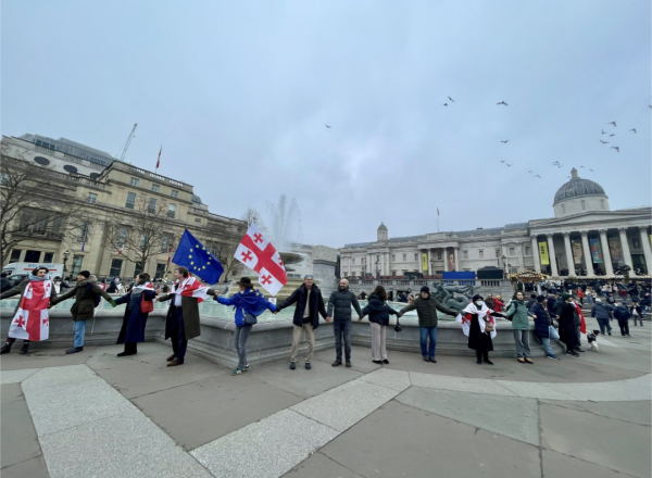 Protestors with Georgia and EU flags join hands across Trafalgar Square in London.