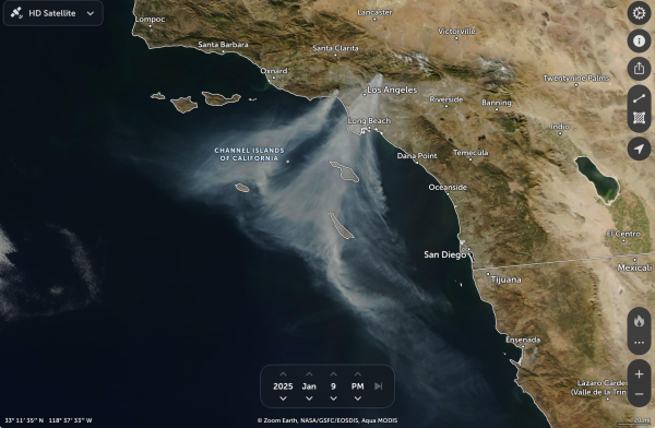 A satellite view of earth above Los Angeles showing a massive amount of smoke drifting mostly from two points near Los Angeles out towards the Pacific Ocean.