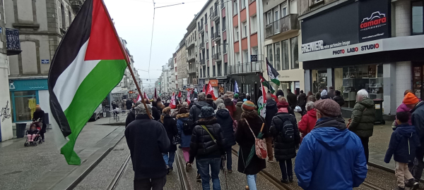 La manif, de dos, dans la rue Jean Jaurès, avec au premier plan un grand drapeau palestinien.