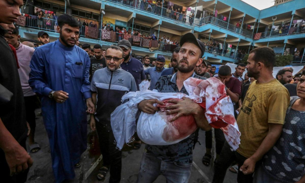 Un desplazado gazatí porta el cuerpo de su hijo, muerto en el ataque de Israel en la escuela de la UNRWA en el campo de Nuseirat. (MOHAMMED SABER / EPA / EFE)