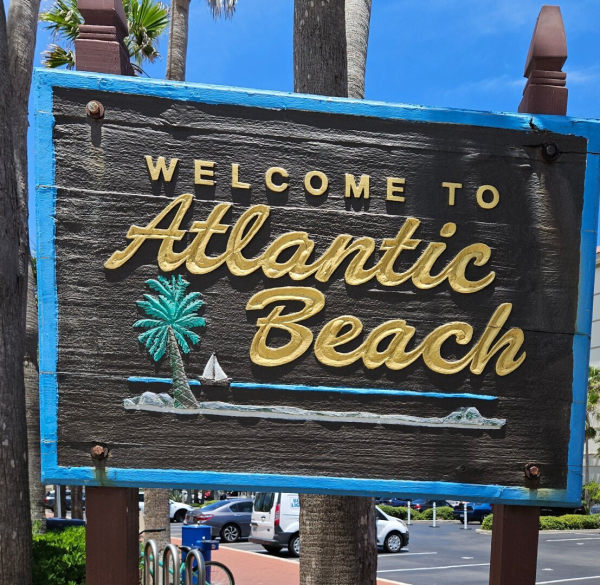 Signage for the Atlantic Beach neighborhood, etched on wood with colorful painting.