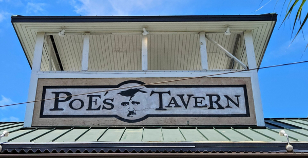 Bar signage for " Poe's Tavern. With a black crow atop image of Edgar Allen Poe's profile.