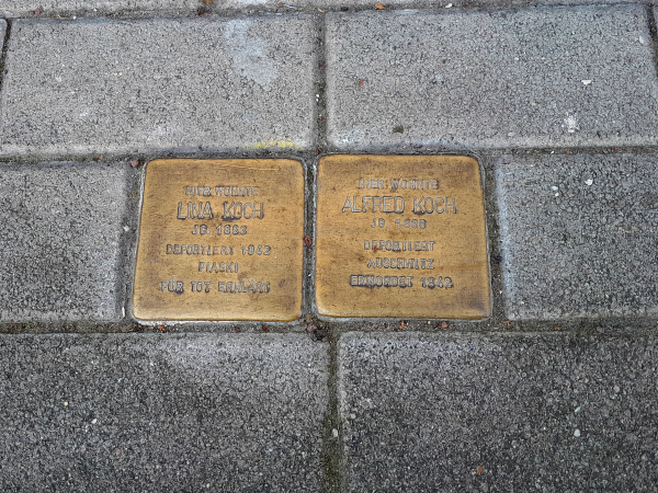 Two brass Memorial [paving] Stones in the sidewalk for Lina and Edward Koch, with birthdates, dates they were taken, and their fate.