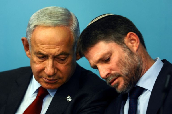 Foto van Benjamin Netalyahu en Bezalel Smotrich. Laatstgenoemde lijkt zijn hoofd op de schouder van Netanyahu te leggen, kennelijk kijken zij naar iets dat Netanyahu (buiten beeld) in handen heeft (mogelijk een smartphone).