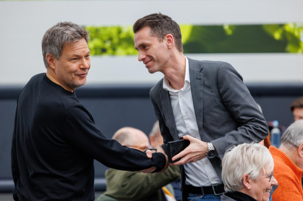 Robert Habeck und Andreas Audretsch begrüßen sich mit einem Handschlag.