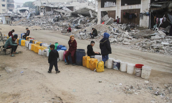 Unos niños hacen cola para recoger agua en la capital de Gaza, el 16 de enero de 2025. (Mahmoud Issa / Reuters)