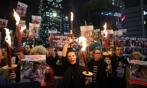 Familiares de los rehenes retenidos por Hamás en Gaza y sus partidarios encienden velas tras conocer el alto el fuego, el miércoles, en Tel Aviv. (ABIR SULTAN / EFE / EPA)