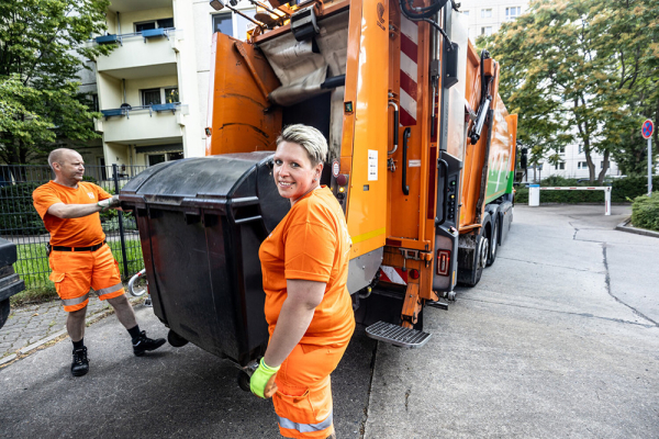 Müllwerkerin und Müllwerker am BSR Müllwagen