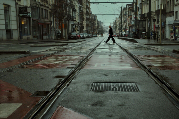 Person crossing the tram tracks on a grey, foggy day