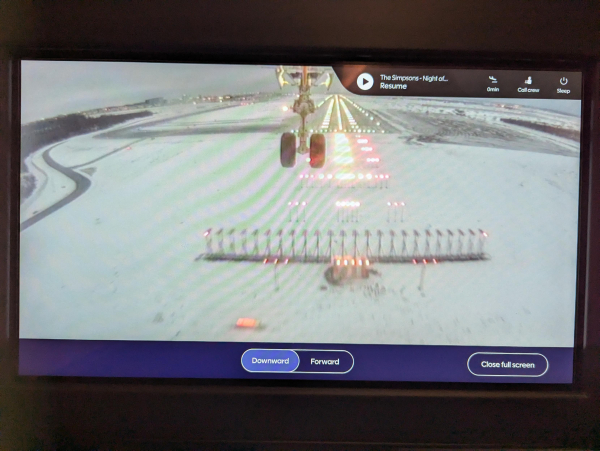 Photo of the external camera view displayed inside a Finnair A350 on approach to land at Helsinki. The front landing gear and a close view of the runway approach lights can be seen.