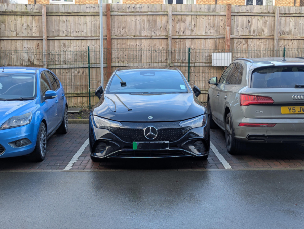 Photo of a Mercedes EQE in a car park.