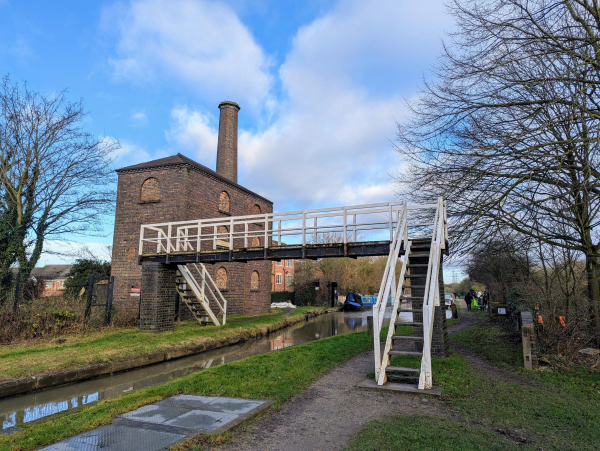 Photo of an old water pumping engine house, a two storey brick building with a large chimney.