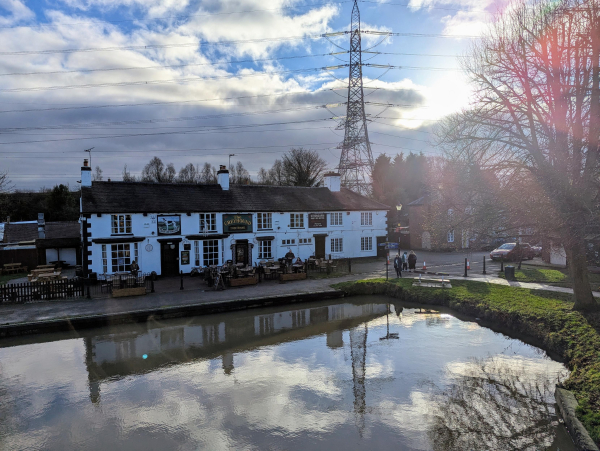 Photo of a white painted inn building next to a canal basin.