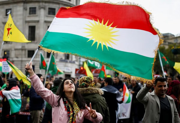 A woman waves a Kurdish flag during a protest