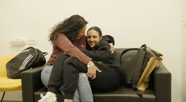 Released Israeli captive Romi Gonen is embraced by her mother, Merav [Israeli military via Reuters]